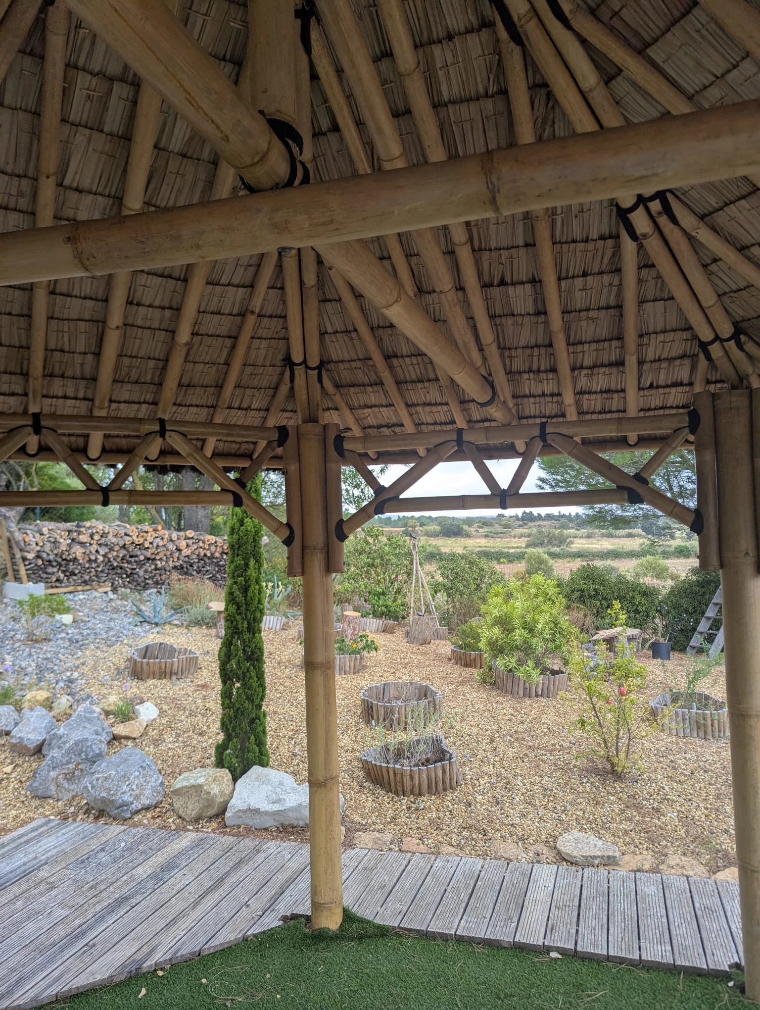 Intérieur d'un gazébo en bambou dans un jardin paysager